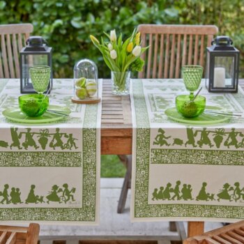 Runner da tavola verde Silhouettes Hansi, un'elegante decorazione ispirata all'arte tradizionale alsaziana. Raffinati motivi raffiguranti scene pittoresche della regione, in rilassanti tonalità di verde, perfetti per arricchire i vostri pasti e le vostre tavole con un tocco di fascino regionale.