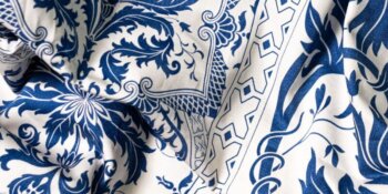 Zoomate sul tessuto Topkapi Original di Beauvillé, rivelandone i motivi raffinati e i colori vivaci. Il tessuto ha una consistenza lussuosa e dettagli finemente intrecciati, che illustrano l'arte del design e l'eccezionale maestria del marchio.