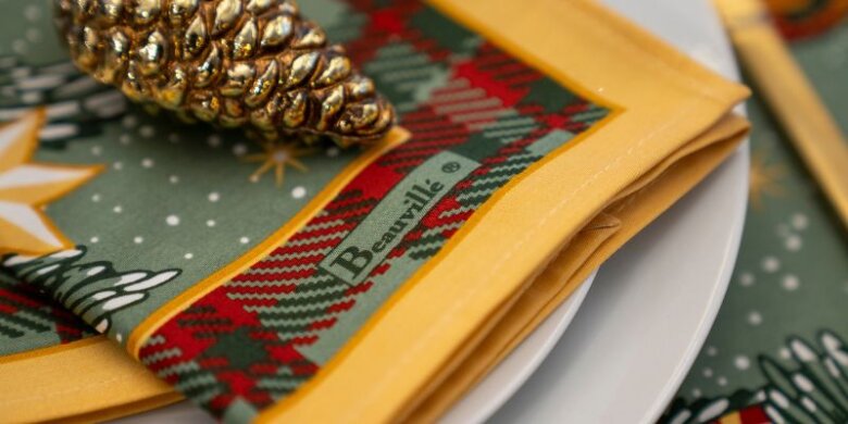 Serviette Trésors de Noël pliée dans une assiette.