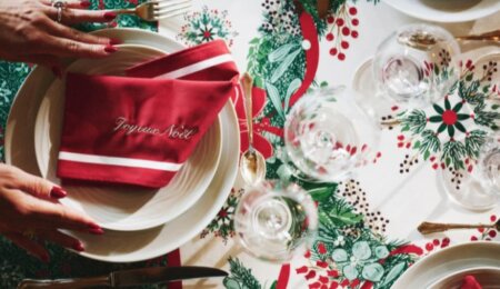 Serviette bicolore rouge et blanc personnalisée avec brodé Joyeux Noël disposée sur la nappe Réveillon.