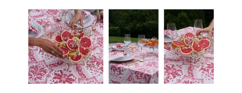 Table dressée avec nappe Topkapi grenadine Beauvillé, assiettes élégantes et centre de table composé de pamplemousses frais.