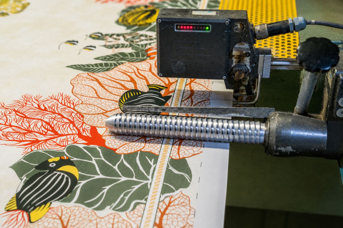 Opération de droit-fil réalisée sur une étoffe imprimée au sein de la Manufacture d’Impression sur Étoffes